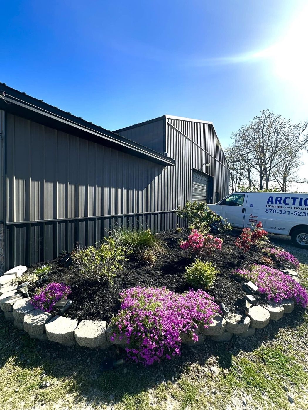 The Arctic Heating and Cooling shop on Hwy 5 South in Mountain Home, with the Arctic service van and spring flower beds out front
